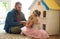 Getting involved in her imaginative play. an adorable little girl and her father playing with a dollhouse together at
