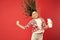 Getting more hair can be simple. Happy child jumping with hair shampoo on red background. Little girl with long curly