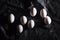 Getting ready for Easter. Seven white eggs on a dark background for coloring