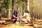 Getting ready to send some smoke signals. two little girls building a campfire while playing dressup in the woods.