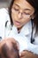 Getting a thorough checkup. A young female doctor examining an infant who has a cleft palate.