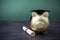 Gfold piggy bank with a grad cap and diploma in front of green chalkboard. Education scholarship