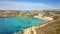 Ghajn Tuffieha, Malta - The beautiful Ghajn Tuffieha Watch Tower and Golden Bay on a summer morning with crystal clear sea water