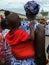 Ghana. The people. A young mother carrying her baby with a red t-shirt at the Fetu Afahye festival in Cape Coast