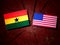 Ghanaian flag with USA flag on a tree stump