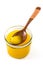 Ghee or clarified butter in jar and wooden spoon isolated