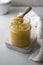 Ghee in a glass jar made with sunflower oil on a light background, copy space for text. Hard light