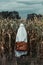 Ghost in glasses with suitcase on corn field