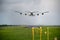 Giant aircraft landing at the airport with runway in the background. Back view