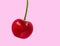 Giant cherry on pink background