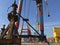 Giant crane on a ship with industrial worker overlooking action.