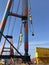 Giant crane on a ship with industrial worker overlooking action.