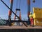 Giant crane on a ship with industrial workers overlooking action.