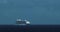 Giant cruise ship in the distant ocean headed towards port