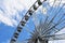 Giant ferris wheel detail. white gondolas. blue sky.