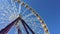 Giant ferris wheel rotating against blue sky