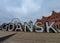 A giant Gdansk sign in front of a ferris wheel and traditional brick building