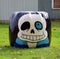 Giant Halloween ghost made out of straw bales in a farm setting.