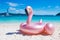 Giant inflatable pink flamingo pool float toy on the tropical be