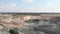 Giant Iron ore open quarry. Large clay pit mining. Aerial view of excavators and machinery loading ore into dump truck in quarry.