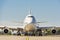 Giant modern civil passenger airliner at airport. Front view of the aircraft. Summer travel concept