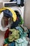 Giant pile of colorful dirty laundry and a washing machine stuffed full with clothes