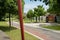 Giant red-painted needle in roadside lawn before building on sun