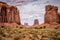 Giant red rock formations rise above the valley on a cloudy day