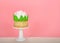 Giant rose cup cake on pedestal, pink background