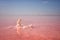 Giant salt crystal in the pink water of extremely salty lake, amazing nature landscape with blue sky and reflection