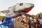 Giant sculpture of shark on a mobile platform scaring people in crowd of the traditional Goa carnival