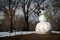 Giant snowman with carrot nose and green scarf. Shot in Central Park with trees and Buildings in background