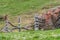 Giant stone boulder on a pasture and destroyed wooden fence, Austria