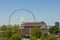 Giant white ferris wheel behind a vintage red brick building in urban Atlanta Georgia