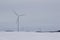 Giant wind turbines on a snow covered rural agricultural landscape