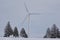 Giant wind turbines on a snow covered rural agricultural landscape