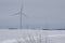 Giant wind turbines on a snow covered rural agricultural landscape