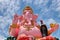 A giantic image of Ganesha in pink color against beautiful sky