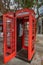 Gibraltar cityscape. Close up of two empty typical English red telephone boxes