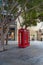 Gibraltar cityscape. Close up of two empty typical English red telephone boxes