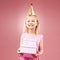 Gift, birthday party and portrait of child with a hat for holiday or happy celebration. Excited girl on a pink