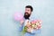 Gift bouquet. Present for spouse. Guy with air balloon. Birthday party. Bearded man hipster with flower bouquet. 8 march