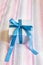 Gift box with blue bow on cute textile background.