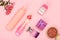 Gift box, bottles of perfume, shampoo, powder and golden ring in box on a pink background. Women cosmetics and accessories.