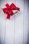 Gift box in glittery paper with bow on wooden board holidays con