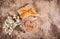 A gift box with a gold bow, white flowers and a wooden heart. A small present with a gold ribbon on a wooden background.