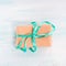 Gift box with green ribbon pastel background. Holiday present