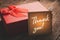 Gift box with a note of gratitude on a wooden table in vintage processing: concept of expression of gratitude and thanks