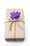 Gift box package wrapped with paper and rope with purple flowers