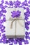 Gift box package wrapped with paper and rope with purple flowers